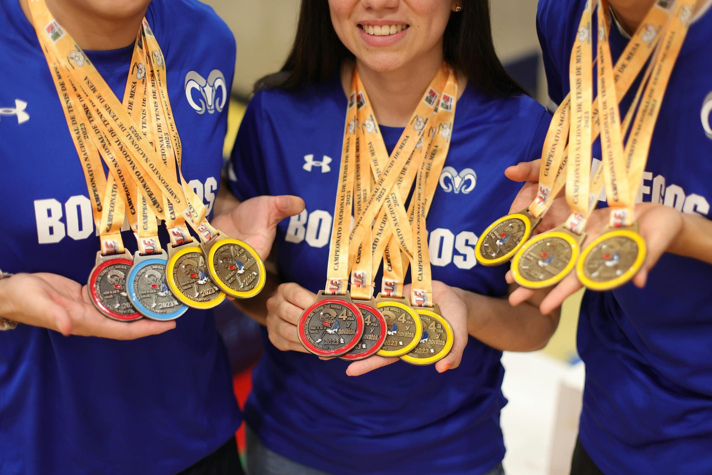 Students holding up medals won at an international competition