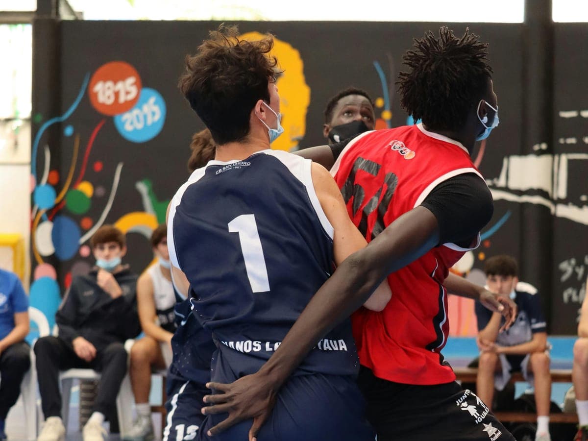 Two young basketball players competing for position during an indoor match