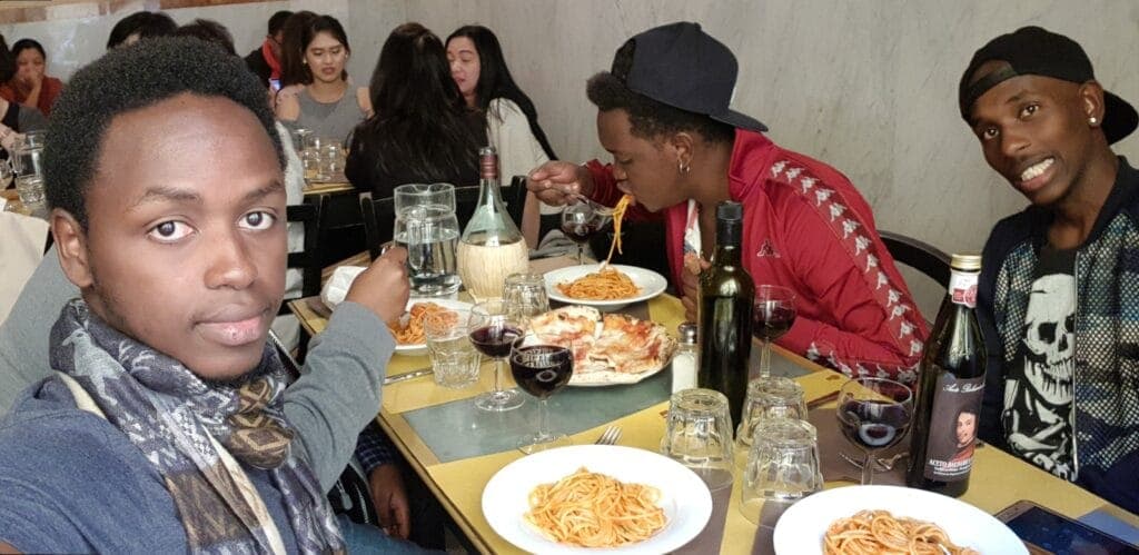 Students sharing plates of pasta at a restaurant