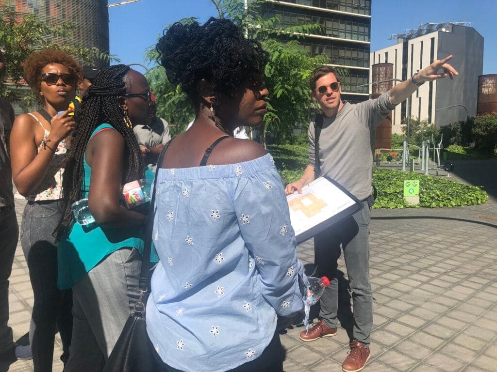 A guide pointing out a building to a student group on a city walking tour
